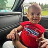 baby, child, smiling, red_shirt, car, car_interior, window, rain, hand, adult, holding, seat, greenery, daylight, portrait, cute, happy, person, clothing, indoors
