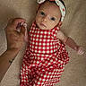 baby, infant, child, hand, finger, red_checkered_clothing, headband, blanket, skin, person, cute, looking, lying_down, small, newborn, soft_texture, indoor, portrait, holding, adult_hand