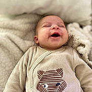 Théo a rejoint le concours — aidez-le/la à gagner de superbes lots ! baby, smiling, infant, blanket, beige, clothing, cute, face, happy, lying_down, newborn, soft_texture, toddler, winking, animal_design, cozy, sleepy, indoor, child, portrait