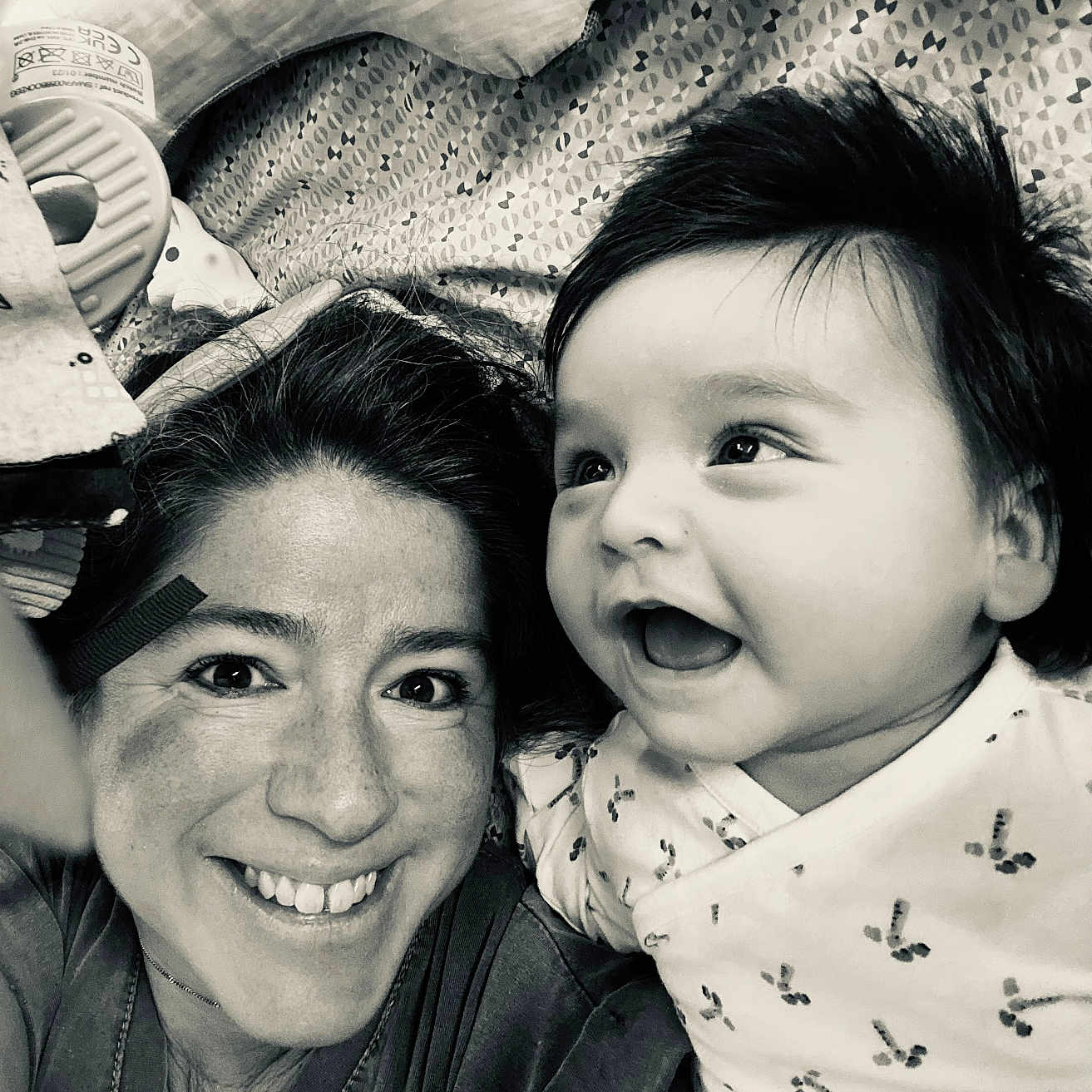 Mathéo participe au concours pour gagner de l'argent avec cette photo : woman, baby, smile, laugh, face, portrait, black_and_white, happy, joyful, closeup, person, infant, child, expression, cozy, indoor, casual, clothing, blanket, hair