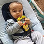baby, infant, toy, baby_rocker, seat, clothing, straps, cushion, indoor, child, person, cute, happy, playful, grey_pants, long_sleeve_shirt, floor, baby_accessory, relaxing, young_child