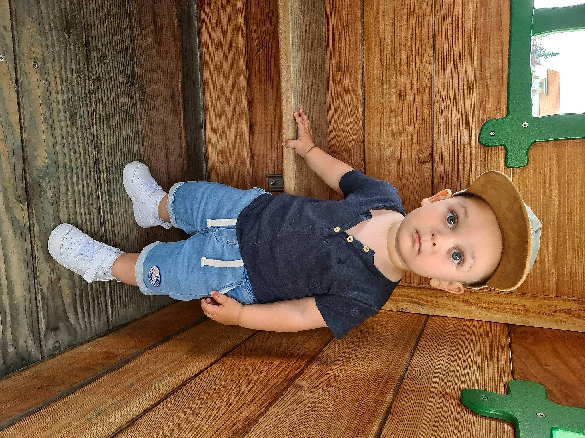 Owenn participe au concours pour gagner de l'argent avec cette photo : baby_toddler_clothing, child, comfort, floor, flooring, fun, green, happy, hardwood, hat, person, plank, sitting, sleeve, smile, surprise, t_shirt, toddler, varnish, wood