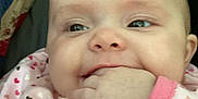 Gracie joined the competition — help win amazing prizes! baby, infant, hand, face, pink_clothing, heart_pattern, chewing, cute, portrait, child, sleepwear, fabric, quilt, colorful, smiling, closeup, skin, eyes, fingers, soft