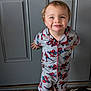 child, toddler, barefoot, pajamas, spiderman, smile, standing, indoors, rug, door, happy, cute, person, clothing, pattern, home, young, face, feet, playful