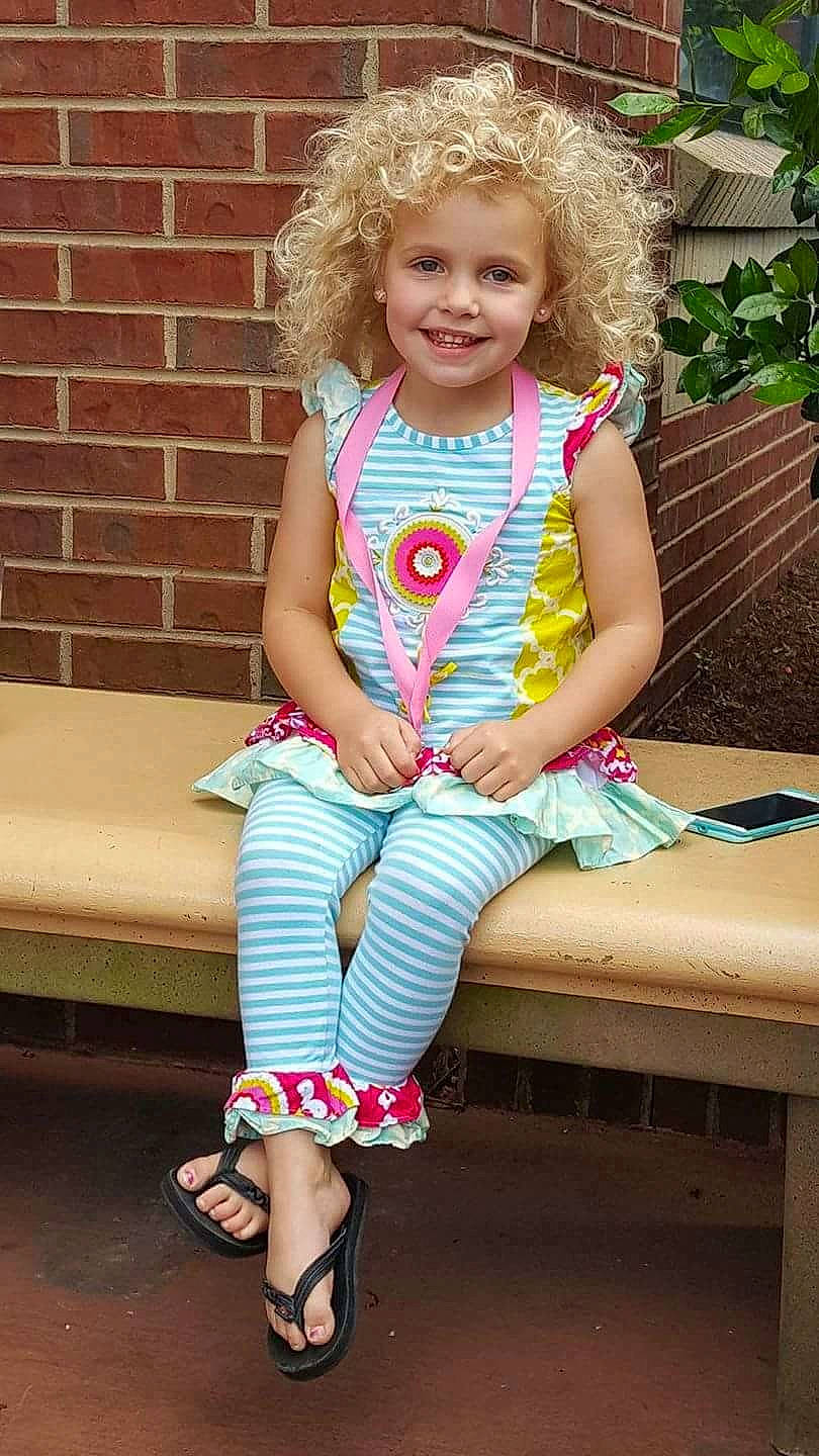 Taylor is registered to the contest to win money with this photo: abdomen, blond, child, day, fun, girl, hair, human_hair_color, jeans, joy, leg, person, pink, shorts, shoulder, sitting, skin, smile, standing, summer