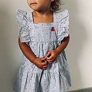 Lila participe au concours pour gagner de l'argent avec cette photo : brown_hair, casual, child, cute, dress, earrings, fashion, floor, girl, hands_together, indoor, looking_away, pensive, polka_dots, portrait, red_bow, standing, striped_dress, wall, young_child