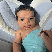Elijah joined the competition — help win amazing prizes! baby, child, towel, water, bath, hand, nail_polish, curly_hair, face, eyes, skin, infant, cushion, seat, indoor, person, portrait, cute, wet, expression