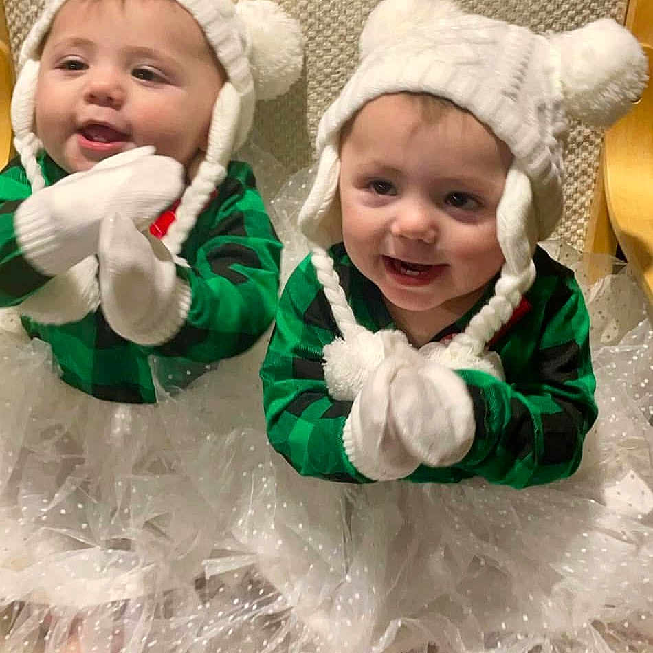 Isabella And Luna is registered to the contest to win money with this photo: baby, bodypart, bonnet, clothing, coat, costume, dress, face, glove, happy, hat, head, jacket, laughing, mouth, person, photography, portrait, smile, teeth