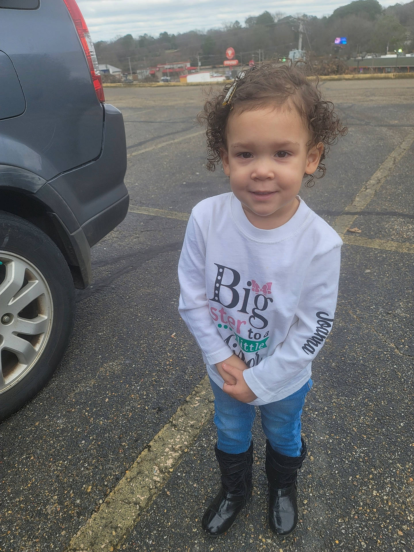 Joanna is registered to the contest to win money with this photo: asphalt, automotive_exterior, automotive_lighting, automotive_tire, bumper, car, fender, joy, motor_vehicle, parking, person, road, sky, standing, t_shirt, tire, toddler, tree, vehicle, vehicle_door