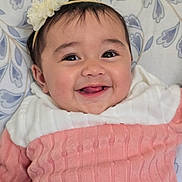 Arya is registered to the contest to win money with this photo: baby, blanket, child, cute, eyes, face, flower, gray, happy, headband, indoors, infant, lying_down, pattern, pink, portrait, skin, smiling, sweater, white