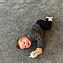 toddler, child, baby_bottle, carpet, smiling, lying_down, clothing, socks, indoor, happy, person, casual, cute, playtime, young_child, infant, floor, relaxed, cozy, resting