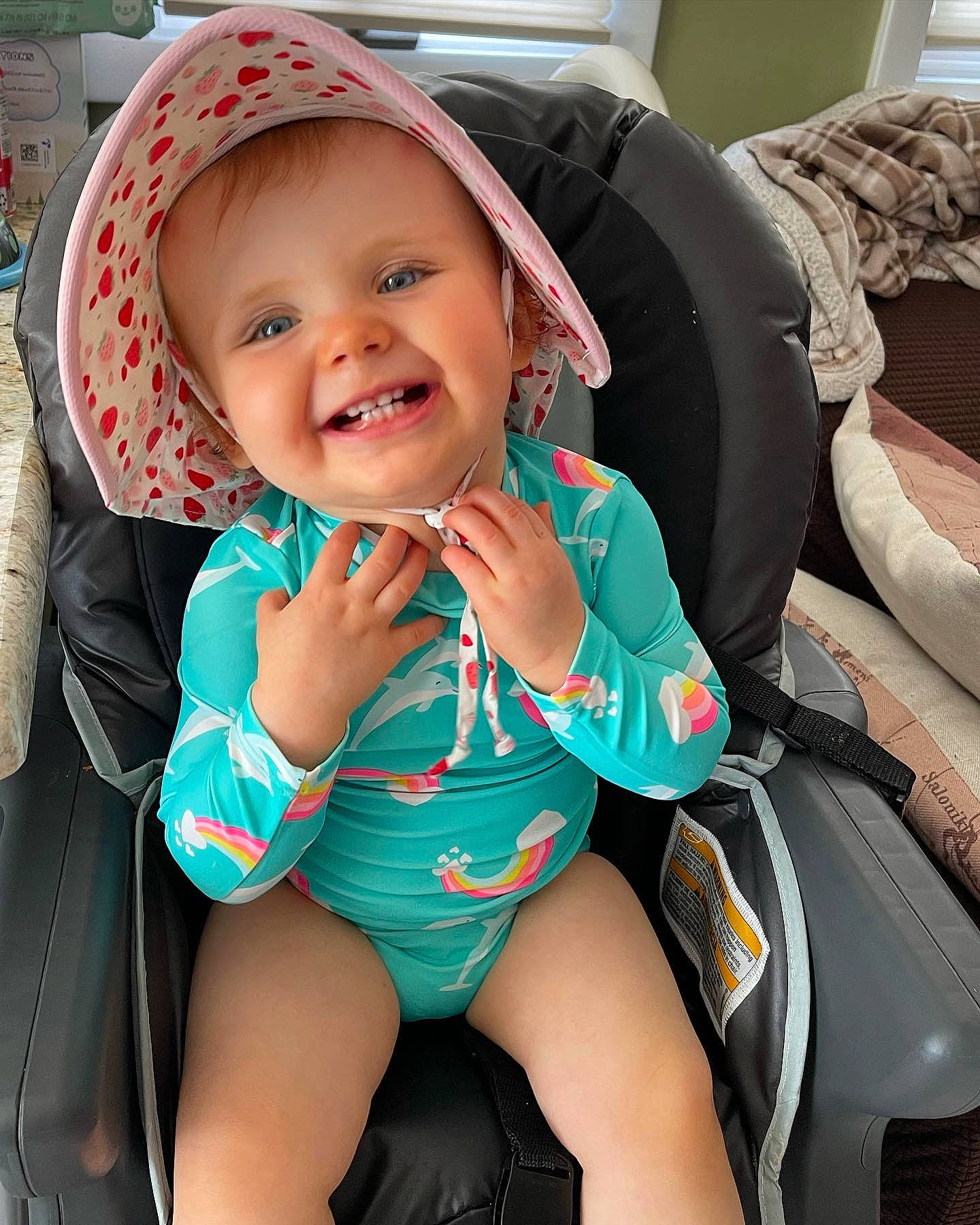 Delaney is registered to the contest to win money with this photo: auto_part, baby, baby_carriage, baby_products, baby_toddler_clothing, cap, car_seat, child, comfort, electric_blue, fashion_accessory, happy, headwear, human_leg, joy, person, personal_protective_equipment, sitting, skin, smile