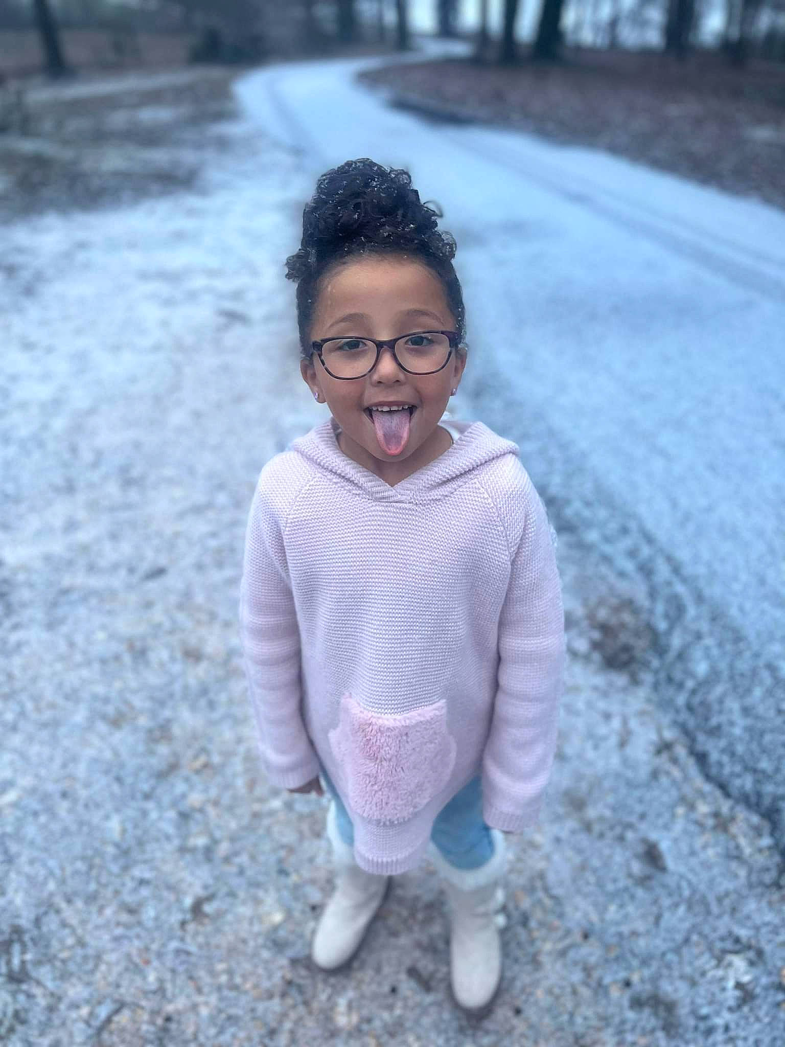 Abigail is registered to the contest to win money with this photo: asphalt, child, electric_blue, eyewear, fun, grass, happy, person, recreation, road, road_surface, sitting, smile, soil, standing, street, t_shirt, toddler, tree, wilderness