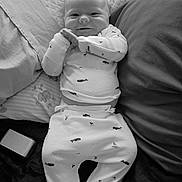 Brandon is registered to the contest to win money with this photo: baby, bed, black_and_white, blanket, clothing, comfort, cute, face, hands, indoor, infant, lying_down, pajamas, person, pillow, relaxed, rest, smile, whale_pattern, young_child