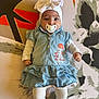 baby, pacifier, headband, bow, denim_dress, white_tights, pink_shoes, infant, child, cute, lying_down, patterned_background, colorful, floral_pattern, clothing, portrait, indoors, small_child, baby_fashion, human