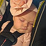 baby, sleeping, car_seat, headband, flower, pink, child, infant, straps, peaceful, face, closeup, soft_lighting, cute, adorable, child_seat, resting, young, portrait, indoors