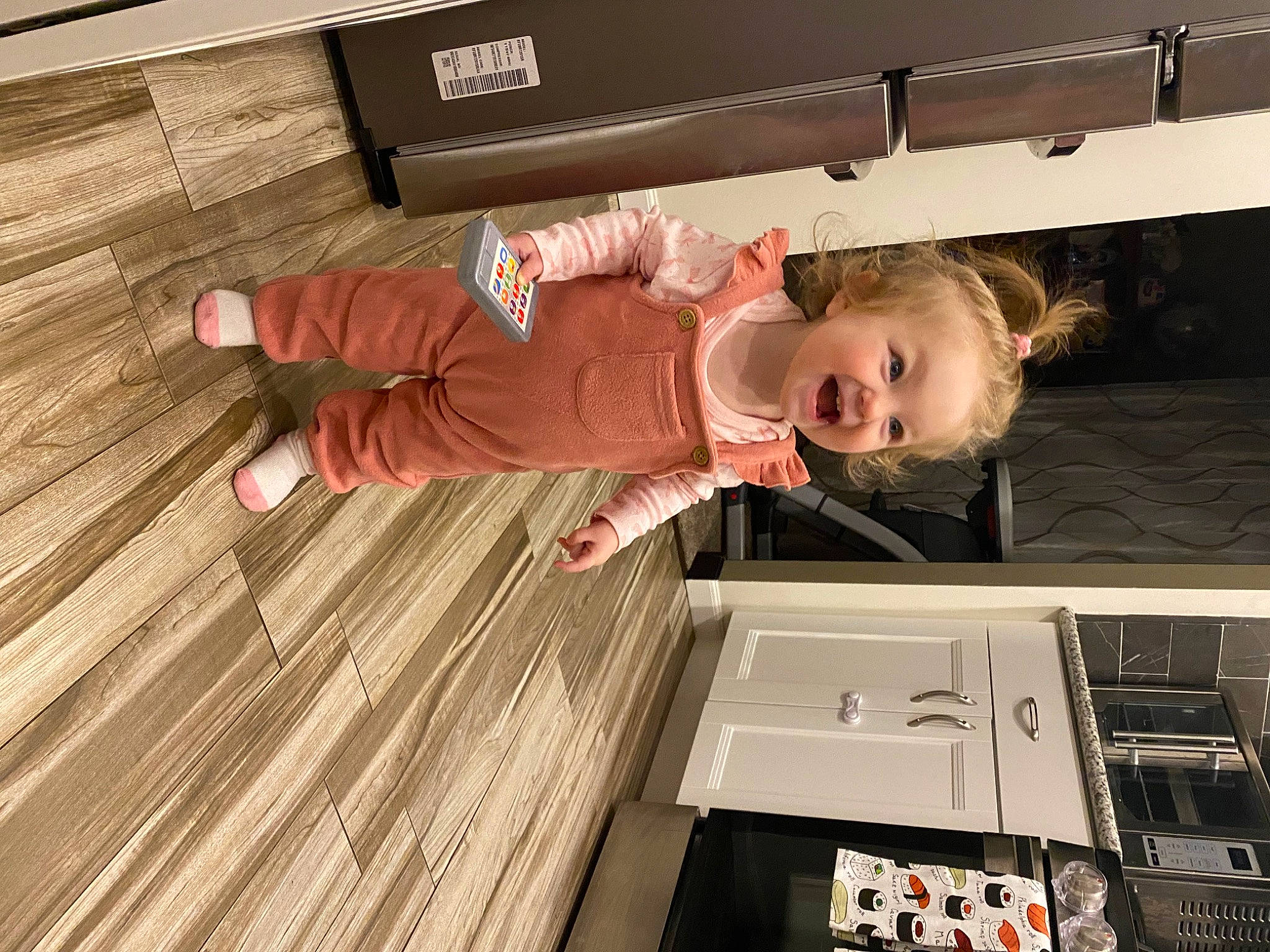 Olivia joined the competition — help win amazing prizes! baby, baby_toddler_clothing, child, comfort, flooring, fun, hardwood, kitchen, machine, pattern, person, room, sleeve, t_shirt, toddler, varnish, wood, wood_flooring, wood_stain