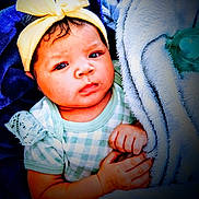 Nova is registered to the contest to win money with this photo: baby, child, infant, blanket, bow, headband, clothing, hand, face, expression, wrapped, soft, cute, indoors, portrait, newborn, pacifier, blue, yellow, green