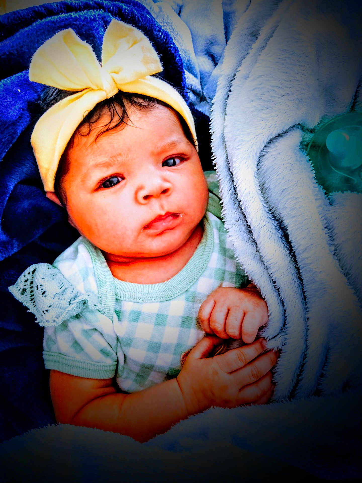 Nova is registered to the contest to win money with this photo: baby, child, infant, blanket, bow, headband, clothing, hand, face, expression, wrapped, soft, cute, indoors, portrait, newborn, pacifier, blue, yellow, green