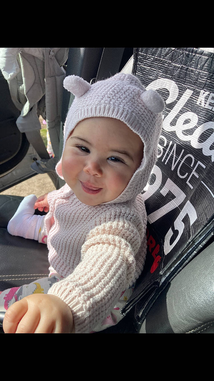 Nila is registered to the contest to win money with this photo: auto_part, baby, baby_carriage, baby_products, bag, beanie, cap, car_seat, child, comfort, eye, fashion_accessory, fun, happy, headwear, knit_cap, person, sitting, smile, toddler