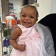 Jasmine is registered to the contest to win money with this photo: toddler, child, smiling, dress, pink_dress, bow, hair_bow, pearl, happy, face, portrait, indoor, person, clothing, sleeveless, skin, baby, cute, tooth, hand