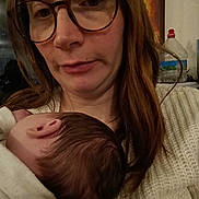 Irys participe au concours pour gagner de l'argent avec cette photo : woman, baby, glasses, indoor, closeup, head, hair, sweater, holding, sleeping, person, portrait, face, cozy, skin, comfort, parent, child, warm, intimate