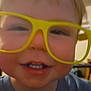 Samuel joined the competition — help win amazing prizes! blurry, cheeks, child, close_up, cute, eyewear, face, glasses, hair, happy, indoor, mischief, person, playful, portrait, shirt, smile, teeth, toddler, yellow_glasses