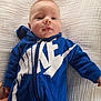 baby, child, blue_hoodie, nike, clothing, infant, portrait, face, smile, hand, blanket, fabric, texture, zipper, casual, young_child, indoor, cute, person, hood