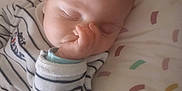 Josélito participe au concours pour gagner de l'argent avec cette photo : baby, sleeping, infant, thumb_in_mouth, striped_clothing, pillow, patterned_pillow, cozy, cute, peaceful, child, young, closeup, face, soft_lighting, indoors, resting, gentle, serene, nap