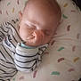 baby, sleeping, infant, thumb_in_mouth, striped_clothing, pillow, patterned_pillow, cozy, cute, peaceful, child, young, closeup, face, soft_lighting, indoors, resting, gentle, serene, nap