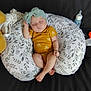 Hazel joined the competition — help win amazing prizes! baby, sleeping, onesie, headband, nursing_pillow, couch, bottle, infant, peaceful, resting, yellow_clothing, patterned_pillow, child, cute, soft, indoor, relaxed, small, adorable, peaceful_sleep