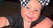 Delilah Rain is registered to the contest to win money with this photo: toddler, child, smiling, headband, bow, checkered, black_shirt, indoor, carpet, table, furniture, cute, baby, person, portrait, happy, hand, face, young_child, curious
