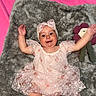 baby, child, infant, dress, lace, headband, smile, happy, plush_blanket, toy, flower, soft_toy, pink_background, lying_down, cute, portrait, indoors, arms_up, baby_girl, fabric