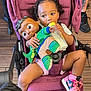 Layla Salley is registered to the contest to win money with this photo: toddler, stroller, baby_bottle, doll, pink_sneakers, child, toy, floor, wooden_floor, person, clothing, hair, seat, footwear, casual, indoor, holding, sitting, cute, playtime