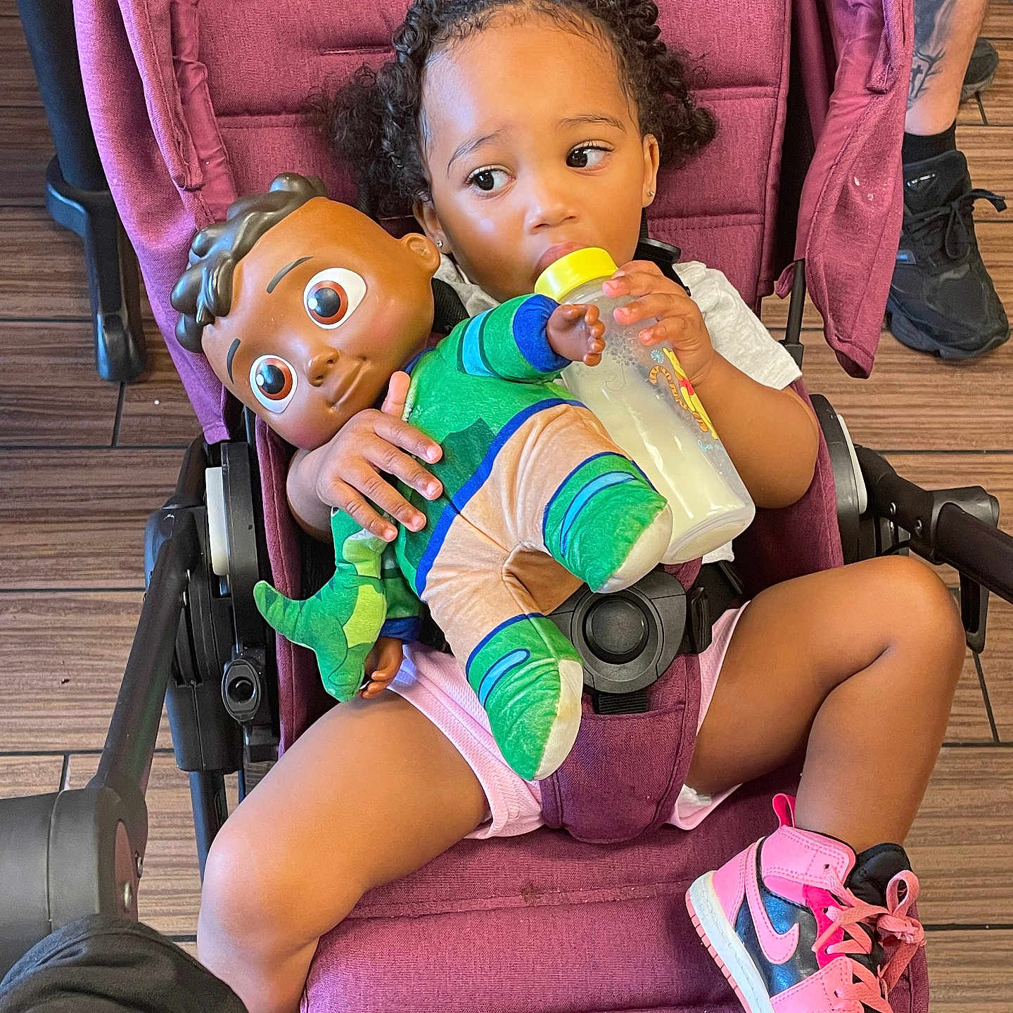 Layla Salley is registered to the contest to win money with this photo: baby_bottle, casual, child, clothing, cute, doll, floor, footwear, hair, holding, indoor, person, pink_sneakers, playtime, seat, sitting, stroller, toddler, toy, wooden_floor