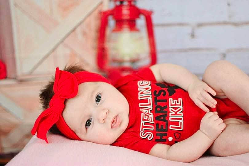 Kaliyah is registered to the contest to win money with this photo: baby, carmine, chest, child, comfort, event, flesh, fun, hand, happy, hat, headwear, human_body, human_leg, knee, person, room, santa_claus, sitting, textile