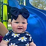 baby, child, smiling, headband, bow, blue_eyes, daisy_pattern, outdoor, playground, slide, blue_slide, green_poles, person, holding_hands, summer, daylight, happy, cute, infant, clothing