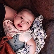 Zailee is registered to the contest to win money with this photo: baby, blanket, couch, infant, person, face, clothing, expression, home, comfort, fabric, soft, cute, indoor, relaxing, child, pattern, warm, skin, portrait