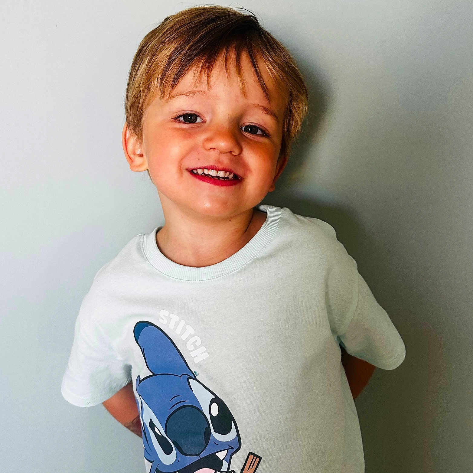 Eden a rejoint le concours — aidez-le/la à gagner de superbes lots ! background, boy, cartoon, casual, child, clothing, cute, expression, happy, ice_cream, indoor, light_hair, person, portrait, smiling, standing, stitch, tshirt, wall, young