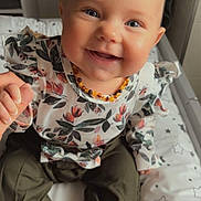 Naya participe au concours pour gagner de l'argent avec cette photo : baby, child, smiling, blue_eyes, floral_top, olive_pants, hand_holding, sitting, cushion, stars_pattern, indoor, portrait, cute, happy, person, clothing, infant, face, head, baby_jewelry