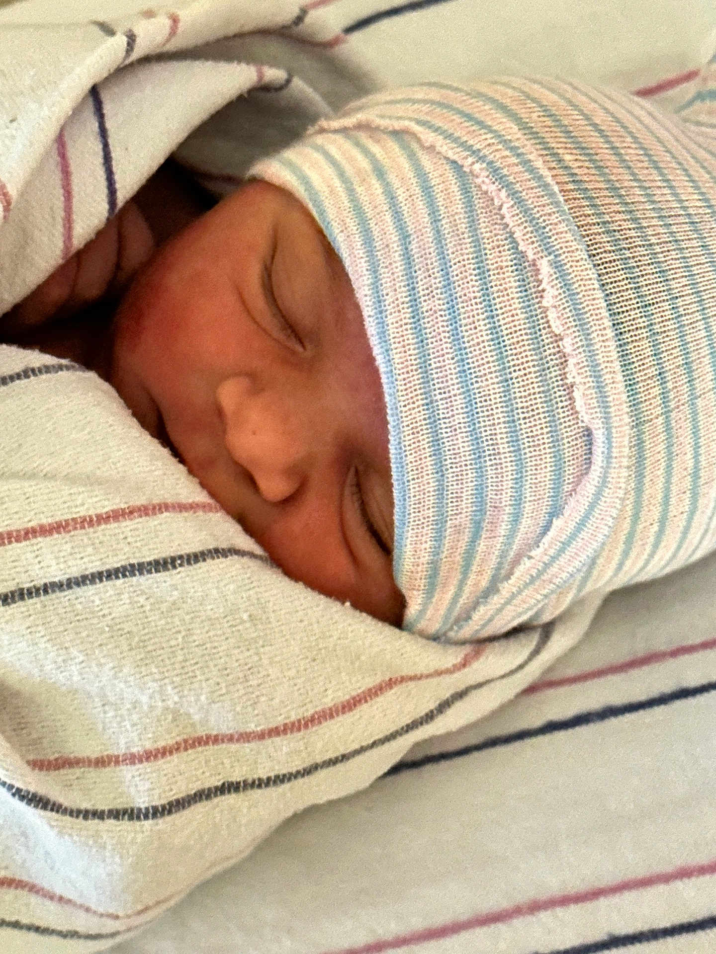 Gabriel joined the competition — help win amazing prizes! newborn, baby, sleeping, blanket, striped_cap, hospital, closeup, face, infant, soft_texture, wrapped, peaceful, cozy, skin, person, headwear, resting, bed, cute, toddler