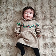 Emy participe au concours pour gagner de l'argent avec cette photo : baby, black_tights, child, comfortable, cozy, cute, face, happy, indoors, infant, lying_down, person, plush_blanket, portrait, smiling, soft_texture, sweater_dress, warm, winter_clothing, young_child