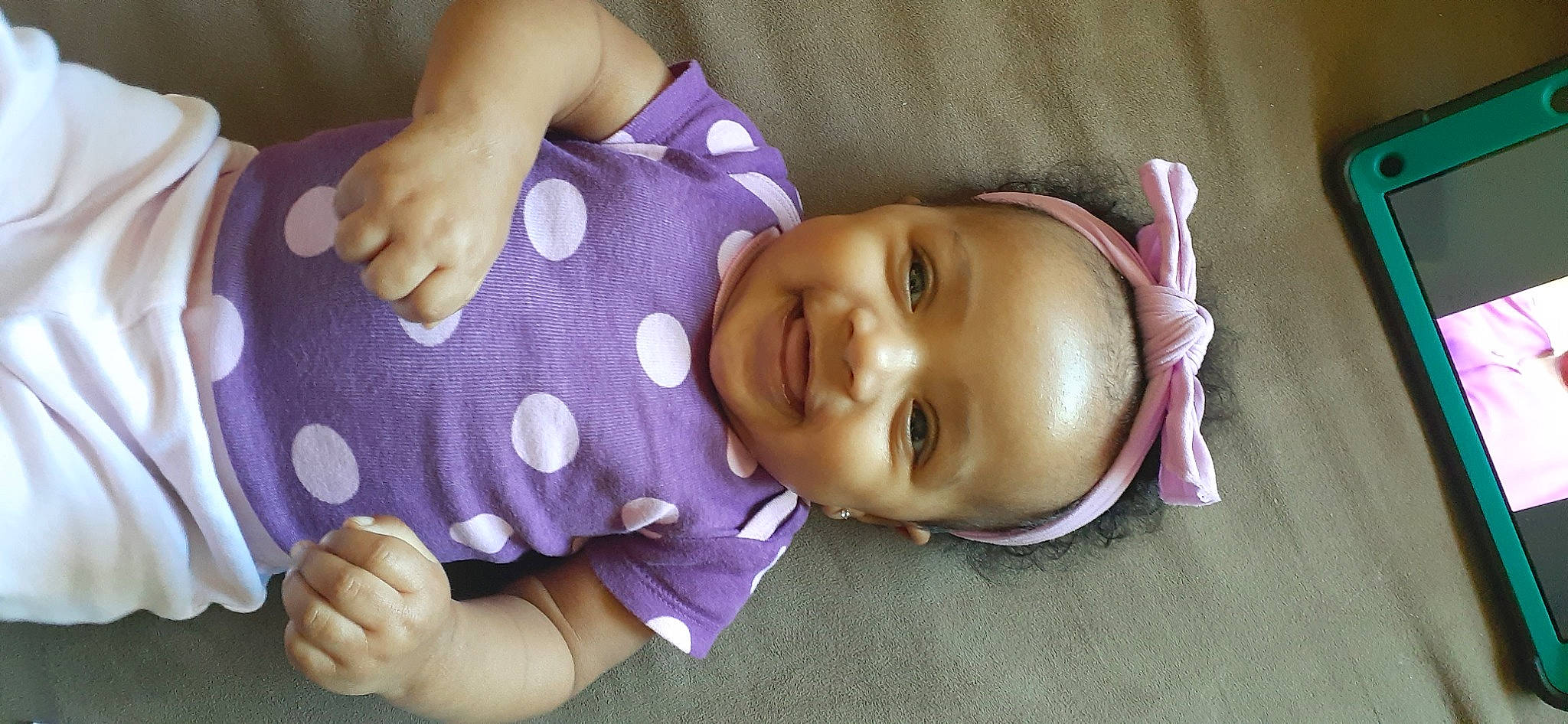 Tamia is registered to the contest to win money with this photo: arm, baby, baby_toddler_clothing, cheek, facial_expression, finger, gesture, happy, human, human_body, iris, joy, lip, mouth, nose, person, purple, skin, sleeve, smile