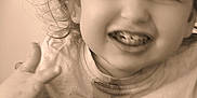 Leo a rejoint le concours — aidez-le/la à gagner de superbes lots ! toddler, child, smiling, high_chair, dinosaur_shirt, messy, sepia, portrait, happy, young_child, indoor, clothing, face, hair, teeth, hand, playful, cute, expression, casual