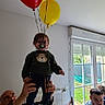 Léo participe au concours pour gagner de l'argent avec cette photo : adult, balloons, casual, chair, child, clothing, curtains, family, green_sweater, hands, home, indoor, light, pacifier, person, radiator, shoes, table, toddler, window