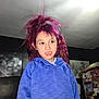 Davina is registered to the contest to win money with this photo: child, person, indoor, blue_hoodie, purple_hair, wild_hair, portrait, casual, expression, room, artwork, clutter, furniture, lighting, young, face, hair_style, curious, standing, candid