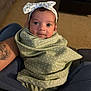 Novalyn is registered to the contest to win money with this photo: baby, infant, blanket, headband, polka_dot, tattoo, arm, carpet, living_room, person, cute, smiling, wrapped, seated, indoor, young_child, comfort, soft, portrait, cozy