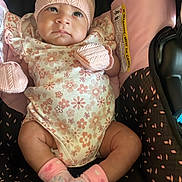 Novalyn is registered to the contest to win money with this photo: baby, infant, child, pink_hat, mittens, socks, onesie, floral_pattern, car_seat, seat_cover, cute, cozy, indoors, portrait, person, small_child, comfortable, apparel, headwear, soft_toys