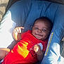 baby, infant, car_seat, red_onesie, smiling, child, cute, sunlight, playful, portrait, seat_belt, blue, outdoor, person, happy, small_child, infant_clothing, baby_girl, baby_boy, relaxing