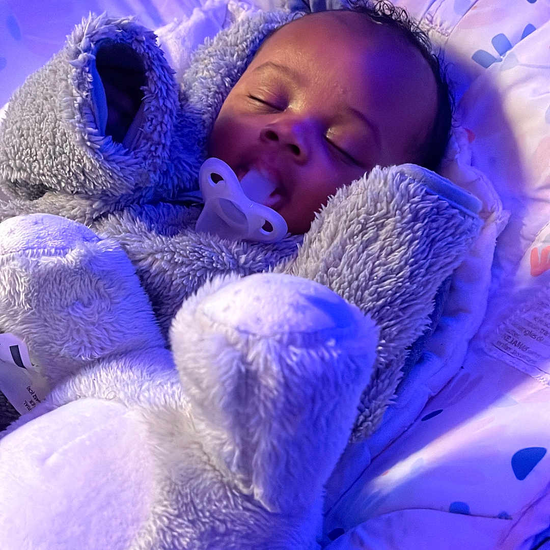 Cylas is registered to the contest to win money with this photo: baby, bed, child, clothing, comfort, cozy, cushion, cute, face, head, indoor, infant, onesie, pacifier, peaceful, plush, purple_light, rest, sleeping, soft